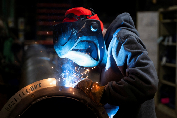 Một công nhân đang hàn ống thép chế tạo bộ phận máy gặt đập liên hợp tại nhà máy ở Mendota, Illinois, Mỹ ngày 21/2.