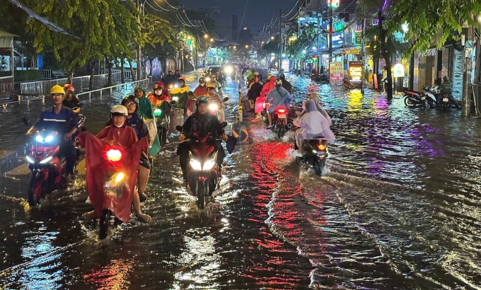 Người dân vất vả lái xe qua đoạn ngập trên đường Nguyễn Văn Khối, quận Gò Vấp.