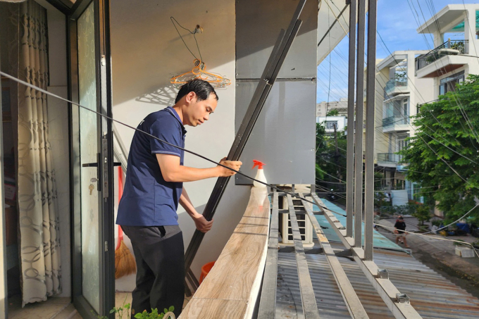 Anh Hoàng Vinh thuê người cưa các thanh sắt chuồng cọp để thông thoáng bancông. Ảnh: Hồ Đinh