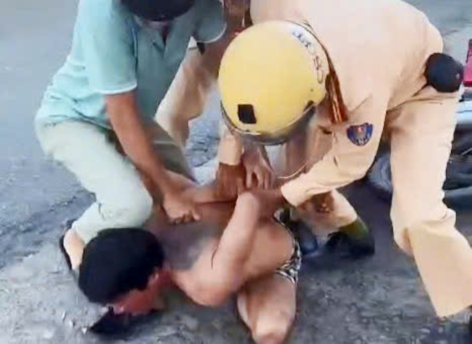 Cảnh sát giao thông khống chế người đàn ông múa dao trên đường. Ảnh: Cắt từ Video