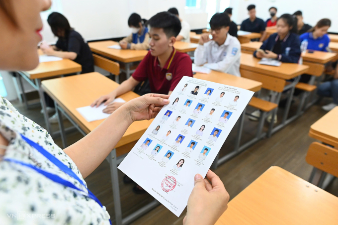 Cán bộ coi thi điểm danh thí sinh trong buổi làm thủ tục dự thi tốt nghiệp THPT, chiều 25/6.