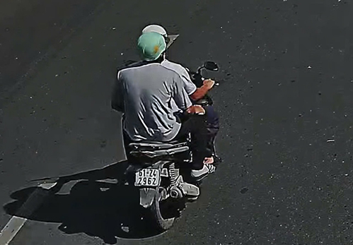 Hai tên cướp trên đường tẩu thoát gắn biển số vào xe. Ảnh: Nhật Vy