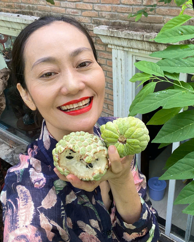 Hạnh Thúy bên cây mãng cầu nhiều trái.