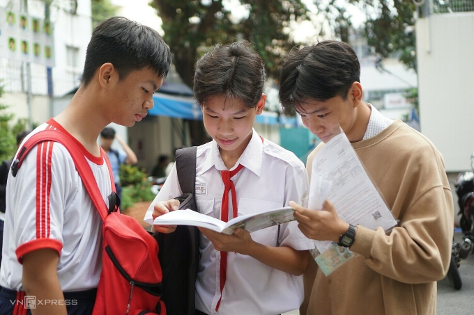 Nhóm thí sinh tranh thủ xem lại một số cấu trúc tiếng Anh trước khi vào phòng thi, sáng 25/4.