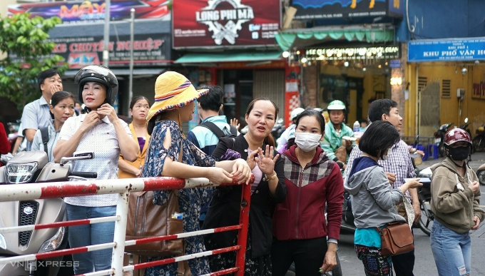 Phụ huynh dõi theo con vào cổng trường thi.