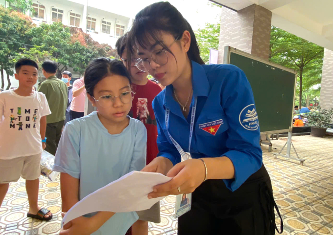 Tình nguyện viên hướng dẫn thí sinh vào phòng thi sáng 8/6.