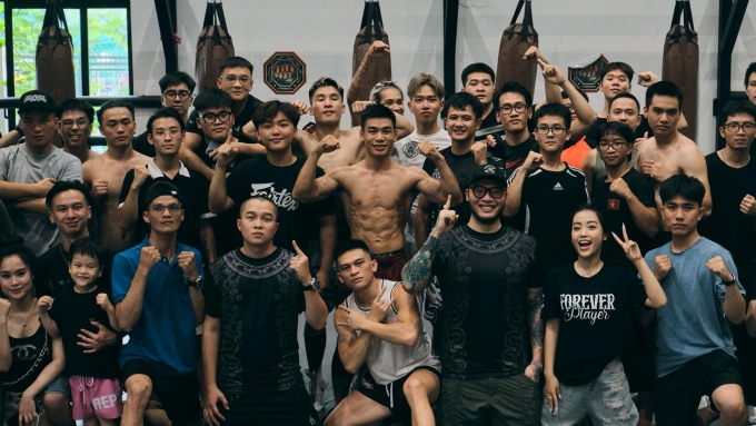 Trần Ngọc Lượng (giữa) chụp ảnh cùng các võ sĩ nghiệp dư và khán giả tại Liên đoàn Võ thuật tổng hợp Việt Nam, Hà Nội ngày 6/7/2025. Ảnh: RVC